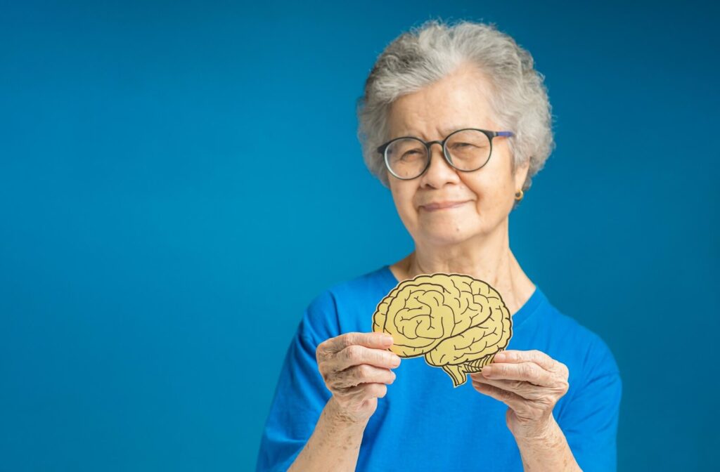 Senior holding a cutout of a brain, symbolizing cognitive health and dementia awareness.