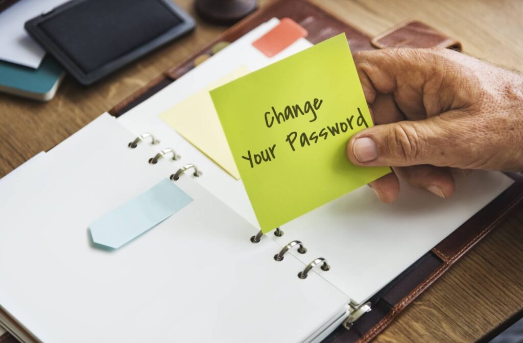 A senior holds a note reminder to change their password, just one of many internet safety tips to protect from scams.