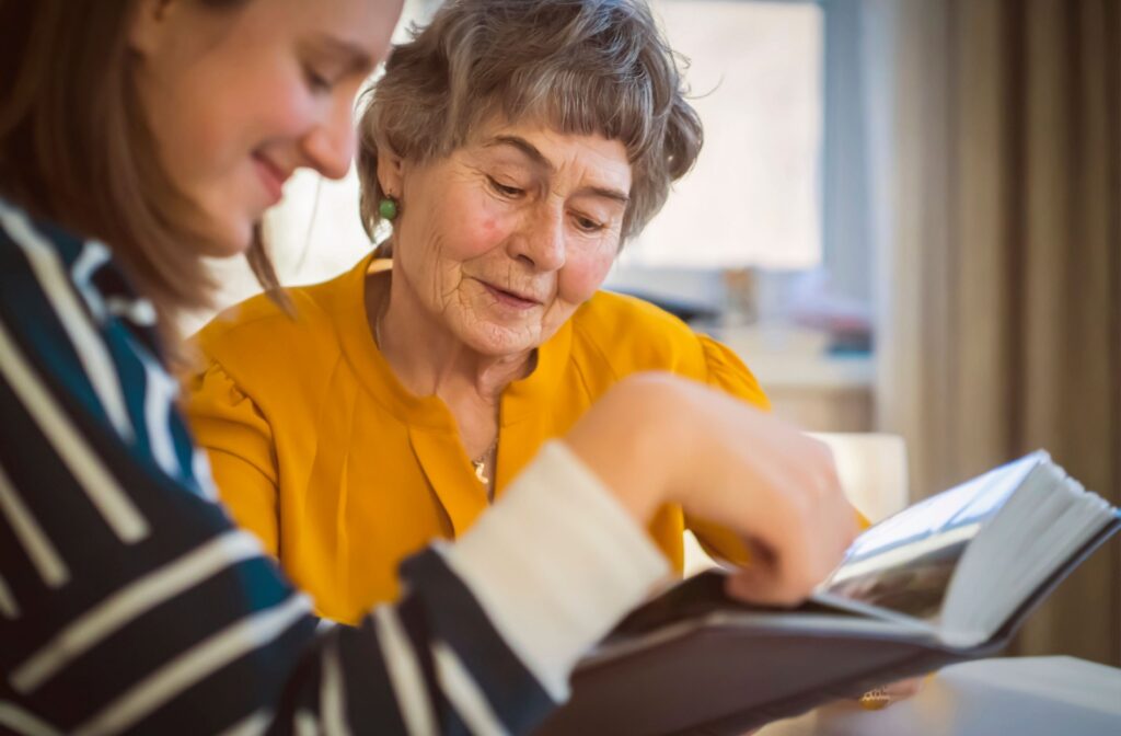 A senior reading with their adult daughter while engaging in a memory exercise together.