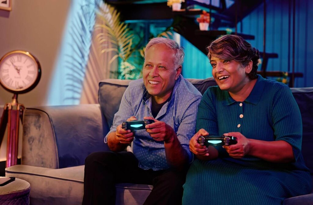 A senior couple happily play video games together as their choice of activity at the end of the day