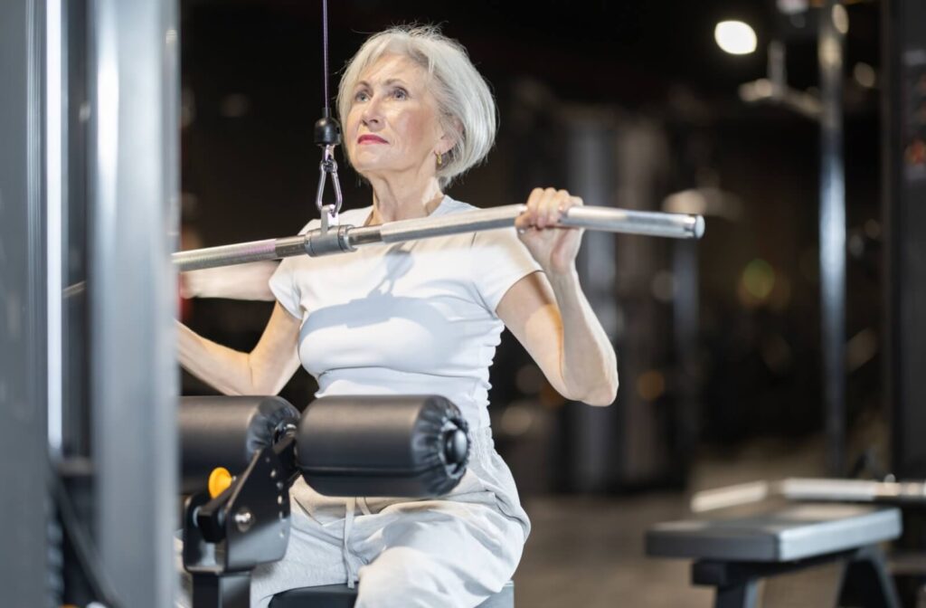 Older adult lifting weights on a machine in gym building bone strength through resistance training and exercise